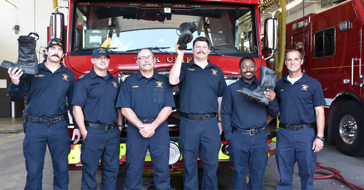 Image of a group of Firefighters standing in front of a fire truck