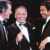 Jerry Lewis standing around chatting with men in tuxes
