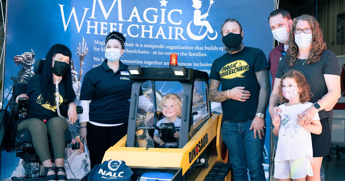 (L to R) Christine Getman, Magic Wheelchair; Jenny McGahan, Muscular Dystrophy Association; MDA family member, Mason in his new 'Dinosaur' front loader wheelchair costume; Scottie Foertmeyer, Magic Wheelchair; MDA family of Mason, at the IAFF Missoula City Fire Fighters Local 271 Station 5 costume reveal for 2020 competition winner, in Missoula, Montana.