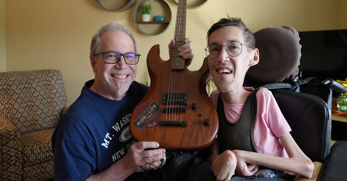 Jon Burcaw with his son, influencer Shane Burcaw with the hand-made, autographed guitar up for auction at this year’s Ride for Life event