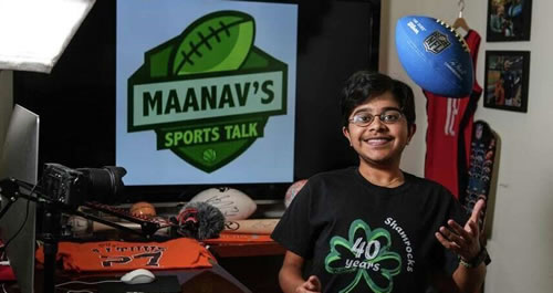 Maanav Gupta in front of a Maanav's Sports Talk banner