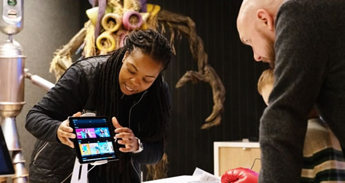 A woman demonstrating a tablet to a man.