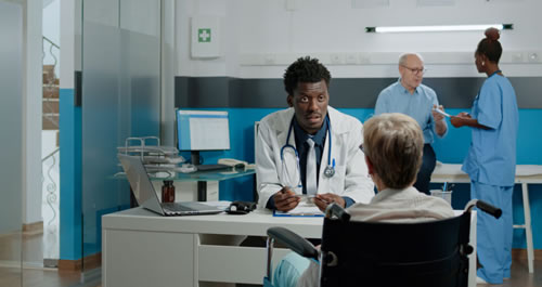 Image of a doctor behind a desk talking to a patient.