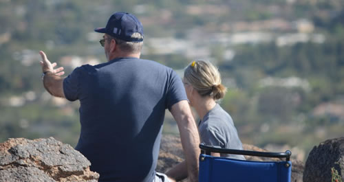 Man and woman sitting on top of a mountain