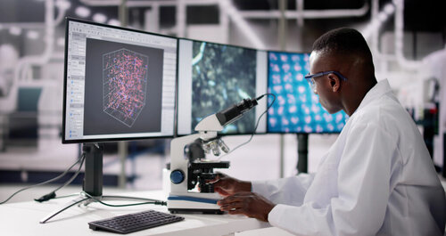 Man with microscope attached to a computer