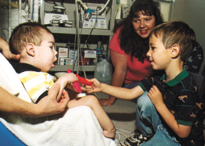 Corbin, 4, likes to try to engage his brother in play. Christian's supply-filled room is often the household's center.