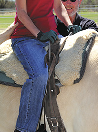 Riders can grip the surcingle’s handles to maintain their balance while riding, and volunteer side walkers walk alongside to offer support when needed.