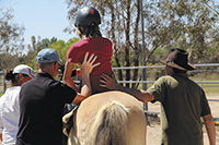 Side walkers offer back support when riders tire and begin to lean to the side.