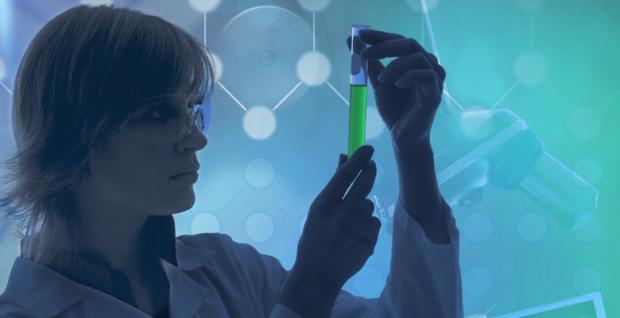 A picture of a scientist with a green vial