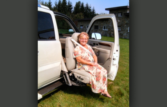 A woman getting out of an SUV using a turning seat system