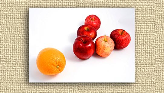 A picture of an orange and several apples