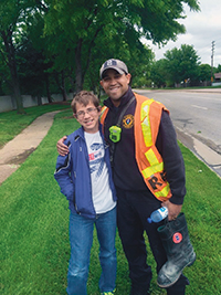 Grant (left) delivers water to a Wichita fire fighter during a Fill the Boot event.