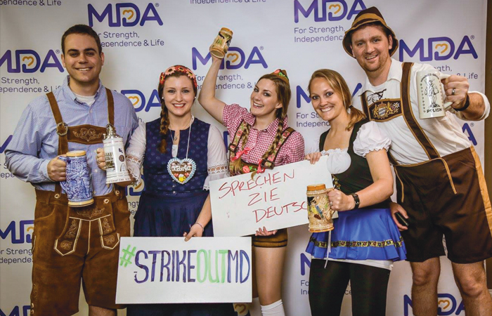 A group of happy people in traditional German clothing, supporting the MDA at an event