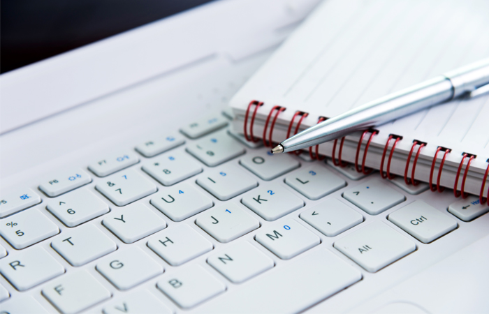 A picture of a pen and paper sitting on top of a keyboard