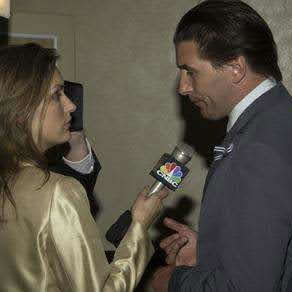 A man in a suit speaking to a reporter from WOWs 2003.