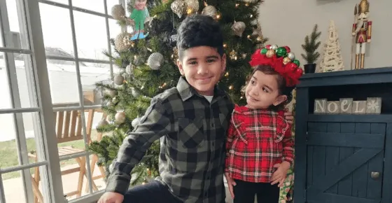 A picture of two kids in front of a Christmas tree.