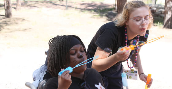 A picture of a couple of people blowing bubbles.