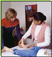 Shree Pandya shows Yvonne Nichols how to do stretching exercises with Scott.