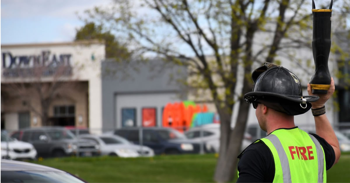 Image of a firefighter holding up a boot with his right arm.