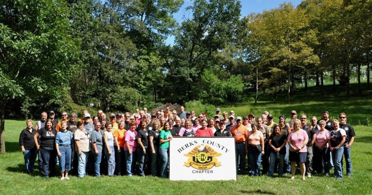 An image of people posing for a group photo on a grass field.