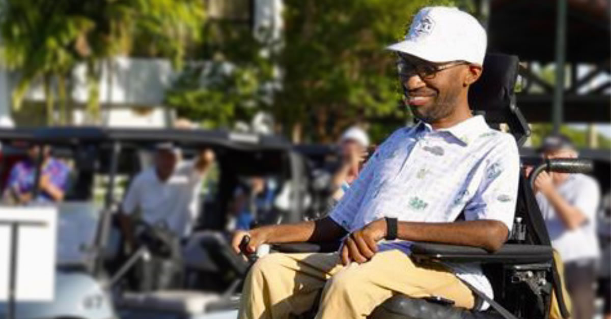 Photo of a guy in a wheelchair playing golf.
