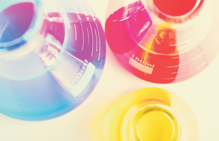 A bright and colorful picture of several beakers full of colored liquids