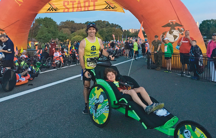 A picture of Will Farr, wearing a Team Momentum jersy, at the start line for the Washington D.C. Marine Corps Marathon