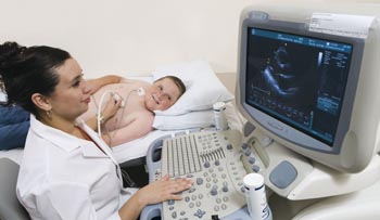 Cardiac sonographer Roxanne Ross performs an echocardiogram, a painless test in which sound waves are transmitted to a computer and converted to an image of Jarrod's beating heart.