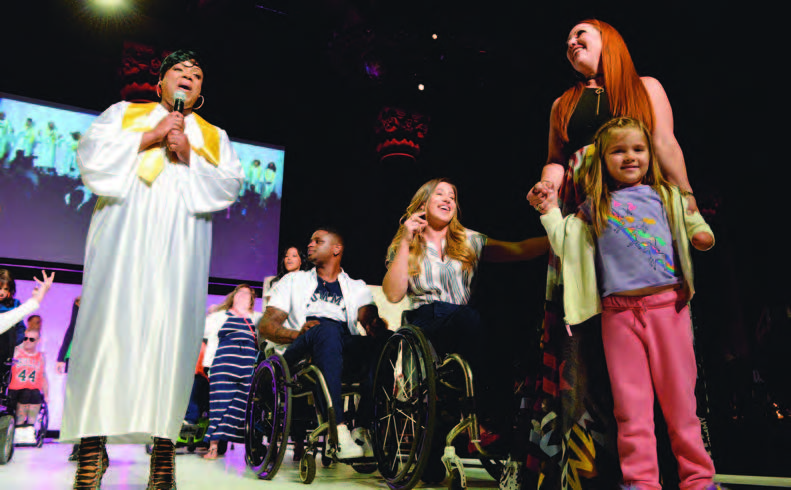 Runway of Dreams founder Mindy Scheier (standing, right) onstage with models during Fashion Revolution